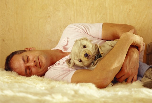 Smiling Man Sleeping with Teddy Bear in His Arms